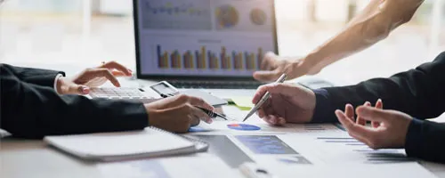 People reviewing charts on paper and laptop